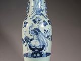 un vase bleu et blanc posé sur un support en bois