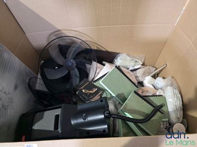 une boîte remplie d'objets divers et un ventilateur