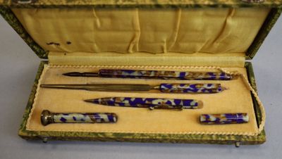 three pens in a case that are sitting on a table