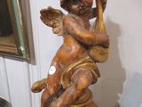 une statue d'un ange tenant une harpe, posée sur une table
