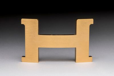 a close up of a wooden letter h on a white surface