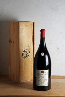 une bouteille de vin posée sur une table à côté d'une caisse en bois