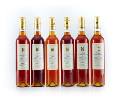 quatre bouteilles de vin sont alignées sur une surface blanche
