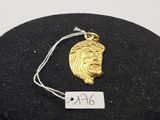 un gros plan sur un collier en or orné d'un visage de Jésus