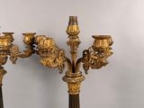 three gold colored candelabs with ornate designs on them