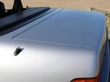 a close up of a silver car with the top down