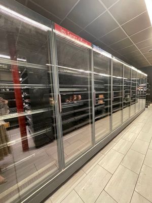 de nombreuses personnes qui se promènent dans les allées d'un supermarché