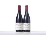 two bottles of red wine sitting on top of a table