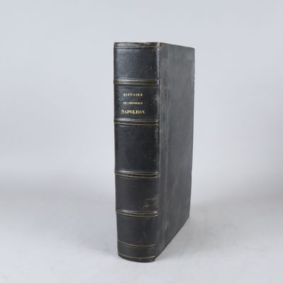 un vieux livre noir posé sur une table blanche