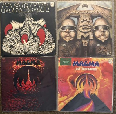 four cd ' s of various albums on a carpeted floor
