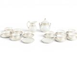 un service à thé blanc avec des tasses et des soucoupes posées sur la table