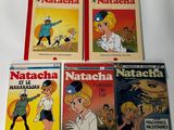 four children ' s books are lined up on a white surface