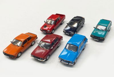 plusieurs petites voitures sont alignées sur une surface blanche