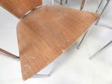 four wooden chairs sitting next to each other on a white floor