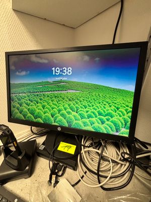 un écran d'ordinateur posé sur un bureau, à côté d'un clavier et d'une souris