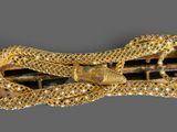 a close up of a gold bracelet with a snake on it
