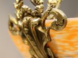 a close up of a vase with a gold decoration on it