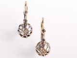 une paire de boucles d'oreilles en or et diamants sur fond blanc