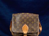 un sac à bandoulière vintage Louis Vuitton sur fond bleu