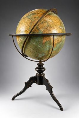 un vieux globe terrestre posé sur un trépied muni d'un socle métallique