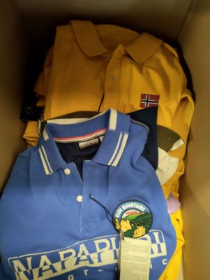 une boîte pleine de vêtements posée sur le sol