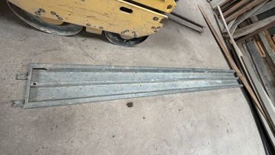 un chariot élévateur garé à côté d'un tas de bois