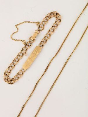 deux chaînes en or et un collier en or posés sur une surface blanche