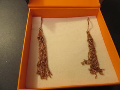 une paire de boucles d'oreilles dans une boîte posée sur une table