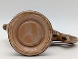 a brown cup sitting on top of a white table