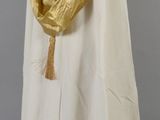 an image of a woman in a white dress and gold shawl on a mannequin