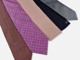 trois cravates de couleurs différentes sont alignées sur une surface blanche