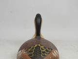 a close up of a small decorative object on a white surface