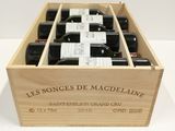 bottles of wine in a wooden box on a white surface