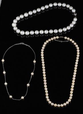trois colliers de perles et un bracelet sur fond noir