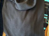 a pile of clothing on a wooden table next to a teddy bear