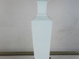 a white table lamp with an orange fringe shade on it
