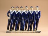 figurines en céramique bleues et blanches représentant des hommes vêtus de tenues de marin