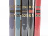 trois livres sont empilés sur une surface blanche
