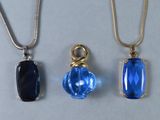 trois colliers composés de perles de verre bleues et d'une chaîne en or