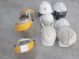 several hard hats are lined up on a cement floor