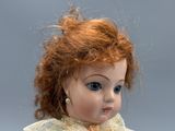 a close up of a doll with a red hair and blue eyes
