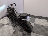 a black motorcycle parked in a room with a checkered floor