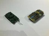 two toy tanks sitting on a table next to each other