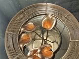 a metal bowl with spoons in it on a table