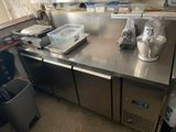 a stainless steel counter in a kitchen with a trash can