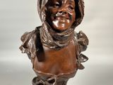 un buste antique en bronze représentant un enfant coiffé d'une capuche