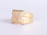 an image of a gold signet ring on a white surface