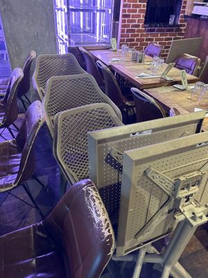 des tables et des chaises dans un restaurant, sur lesquelles est posée une télévision
