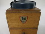 a small wooden box with a black lid and a lion emblem on it