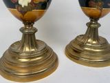 two vases with flowers painted on them sitting on a table